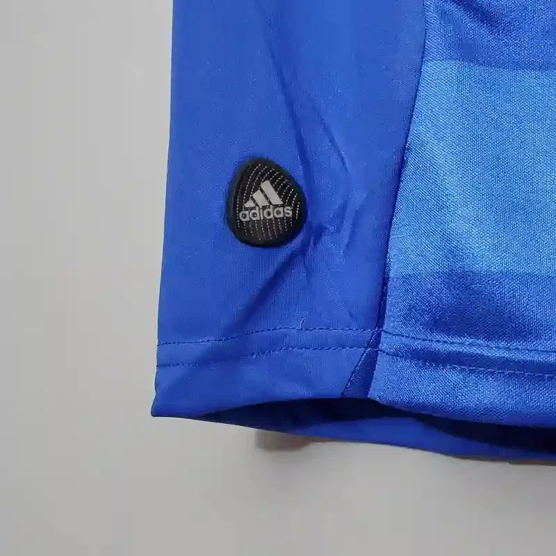 Detalle de manga de camiseta azul retro de fútbol con logo de Adidas